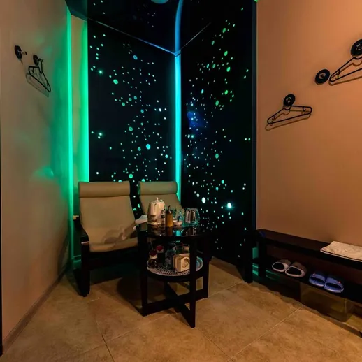 Уютный уголок для отдыха с креслами, столиком и приятным освещением в спа-салоне