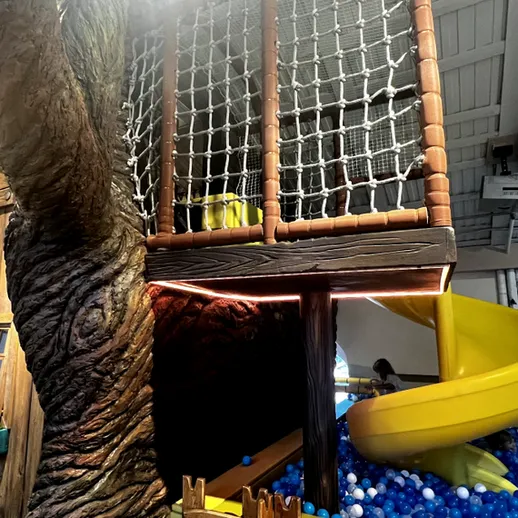 Игровая площадка с горкой и натуральными элементами в закрытом помещении для детей