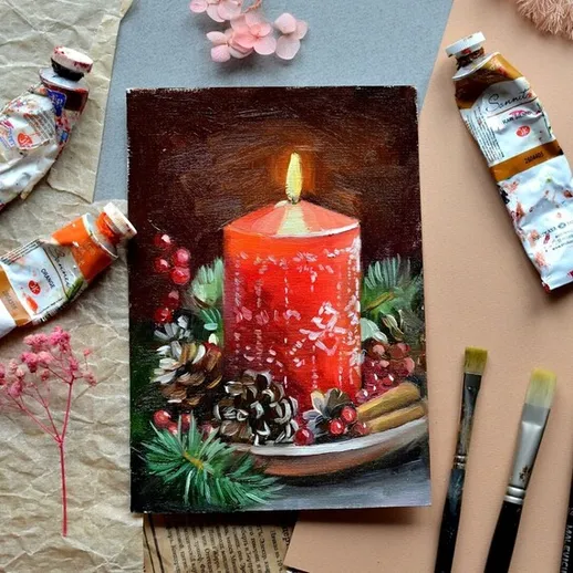 Ручная работа с красной свечой на фоне художественных материалов и декоративных элементов