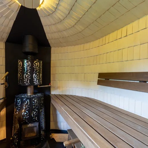 Уютная баня с печью и деревянными полками для отдыха в вечернее время