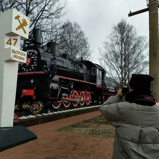Паровоз на постаменте в историческом парке рядом с железной дорогой в холодный день весны