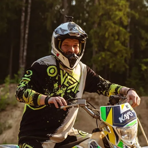 Мотоциклист на тренировке по мотокроссу в лесу в солнечный день