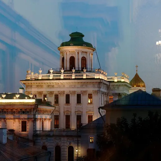 Вечерний вид на историческое здание с куполом и подсветкой в центре города