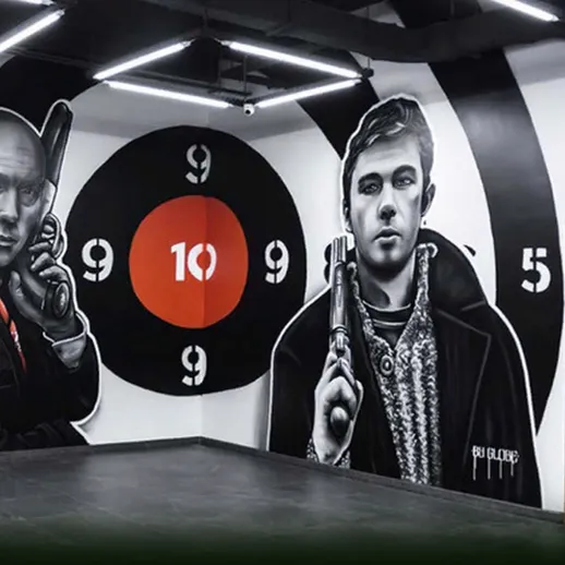 Уличное искусство с Murals на стенах, изображающими людей с оружием в помещении для тренировки стрельбы