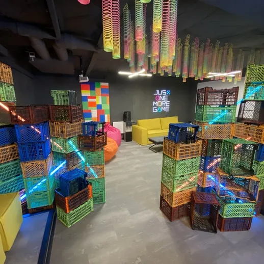 Игровое пространство для детей с конструкциями из пластиковых ящиков и световыми эффектами в помещении