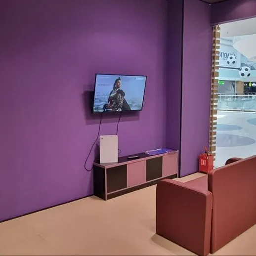 Уютный уголок в торговом центре с телевизором и мягким креслом