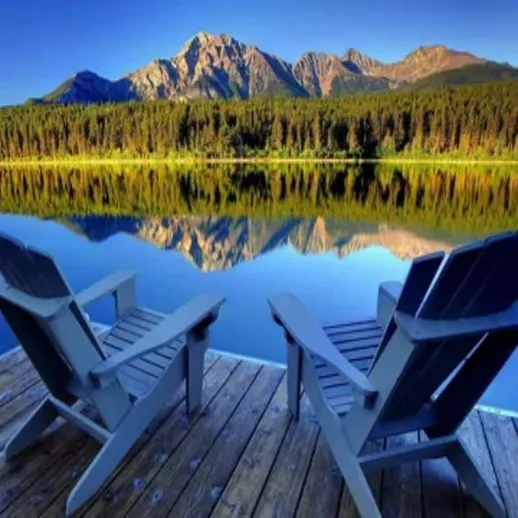 Уютные кресла у озера на фоне горного пейзажа в ясный солнечный день