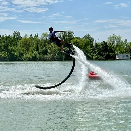 Мужчина выполняет трюк на флайборде на озере в солнечный день