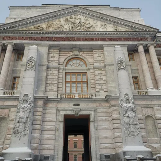 Зимняя архитектура исторического здания с колоннами и скульптурами в центре города