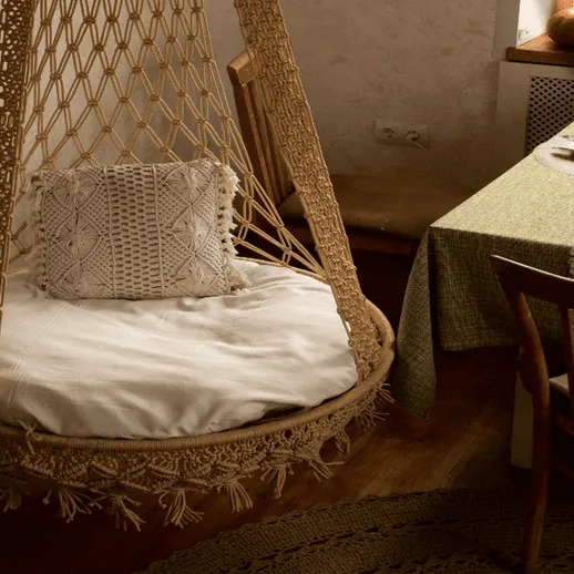 Уютное кресло-качели в интерьере комнаты с деревянной мебелью и пастельными тонами