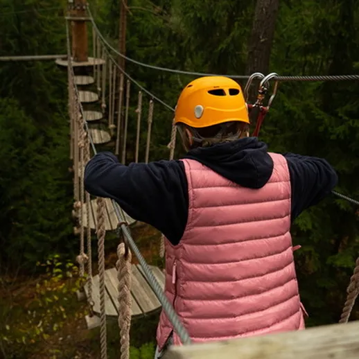 Сложный маршрут на подвесном мосту в лесу с ребёнком в защитном шлеме и ярком жилете