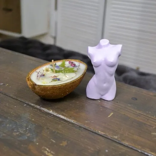 Декоративные предметы на деревянном столе, свеча в кокосе и статуэтка, интерьер в современном стиле