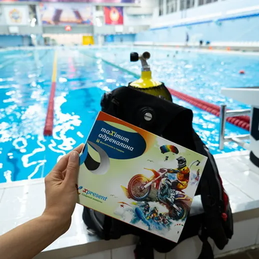 Человек с буклетом о водных видах спорта у бассейна во время тренировки