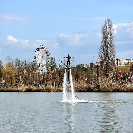Человек на водном дроне в парке с аттракционами и колесом обозрения в ясный солнечный день