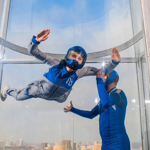 Воздушный туризм в туннеле свободного падения: участник тренируется под руководством инструктора