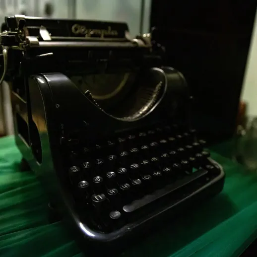 Стилусный механизм старой печатной машинки на зеленом фоне в антикварном магазине