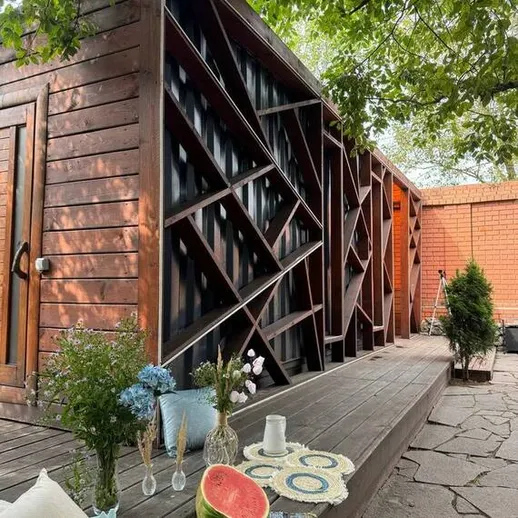 Уютный загородный дом с деревянной террасой и свежими угощениями на столе в летний день