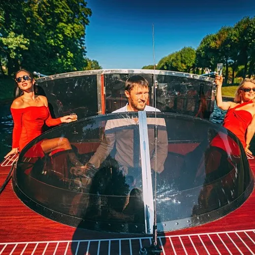 Человек и две женщины на лодке, наслаждающиеся солнечным днем на канале