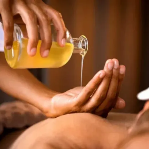 Масляный массаж в спа-салоне с использованием натурального масла и цветка на заднем плане