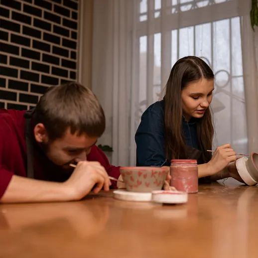 Молодая пара занимается художественной керамикой в уютной мастерской в пасмурный день