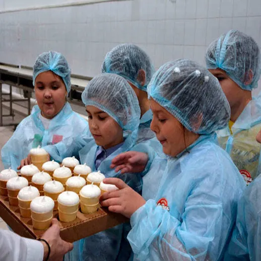 Дети в защитной одежде с мороженым в школе, радостно принимают угощение в столовой на мероприятии