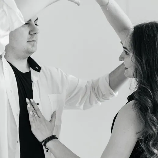 Танец двух людей на светлом фоне, мужчина и женщина соблюдают близость и ритм, осваивая новые движения вдвоем