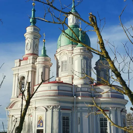 Церковь с зелеными куполами на фоне голубого неба и зимних деревьев в день ясной погоды