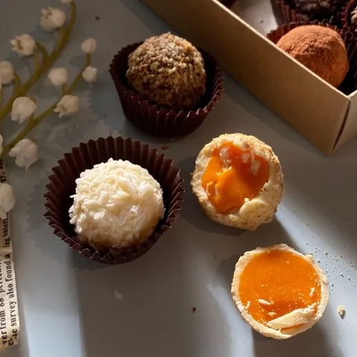 Набор вкусных конфет в коробке с различными начинками на фоне весенних цветов и газет