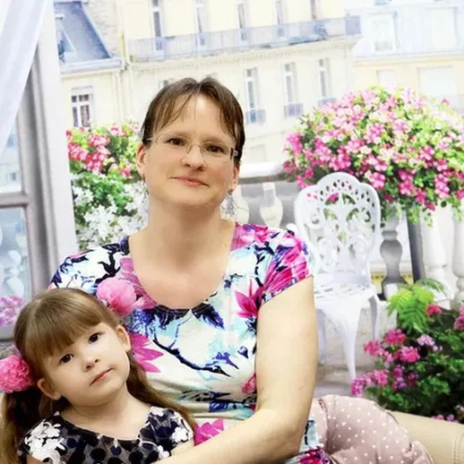 Мать с дочерью на балконе с цветами в Париже в солнечный день