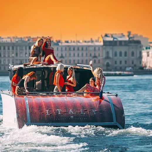 Группа девушек наслаждается прогулкой на катере в красивом закате над водами города