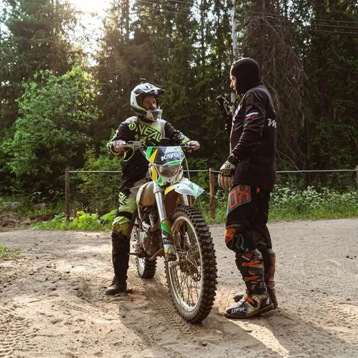 Тренировка гонщиков на мотоциклах в лесу в теплый вечер