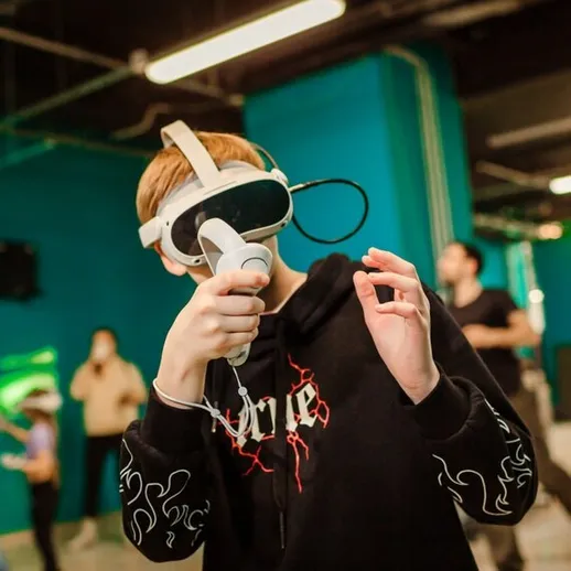 Мальчик в виртуальной реальности в игровом центре, наслаждаясь новыми технологиями в свободное время