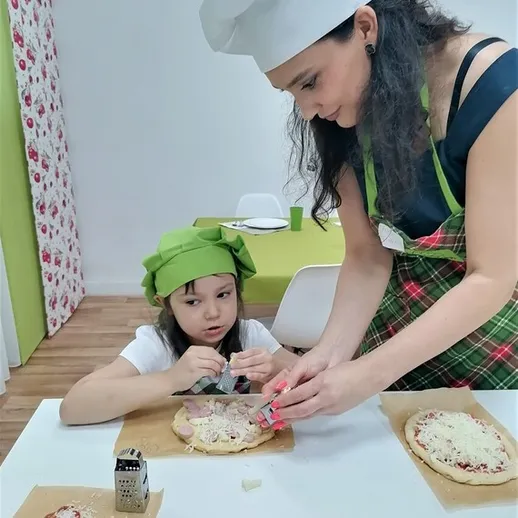 Мама и дочь готовят пиццу вместе в уютной кухне в теплый вечер