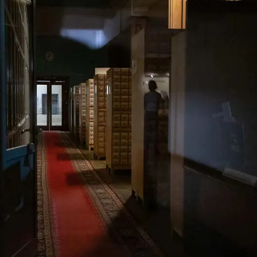 Тихий коридор библиотеки с книжными шкафами и красным ковровым покрытием в вечернее время