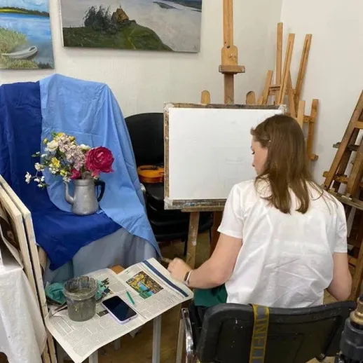 Художница работает над натюрмортом в творческой мастерской