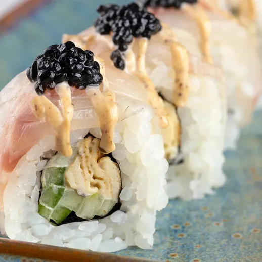 Вкусные суши с черной икрой и соусом в японском ресторане