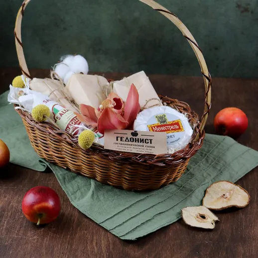 Корзина с натуральными продуктами и яблоками на зеленом фоне, уютная атмосфера для осеннего угощения