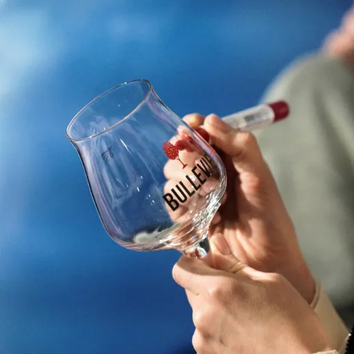 Участник мастер-класса по дегустации крепких напитков с бокалом и подписью на мероприятии в городе