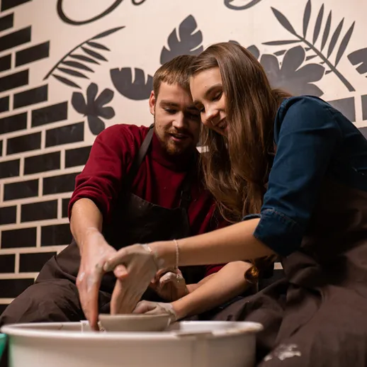 Два человека учатся лепке из глины в художественной студии с уникальным дизайном интерьера