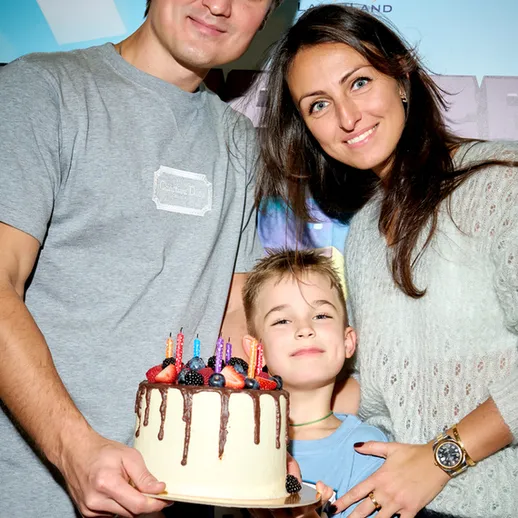 Семейное празднование дня рождения с тортом и улыбающимися людьми