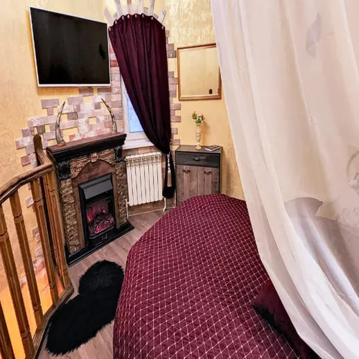 Уютная спальня с камином и телевизором в загородном доме на ночь