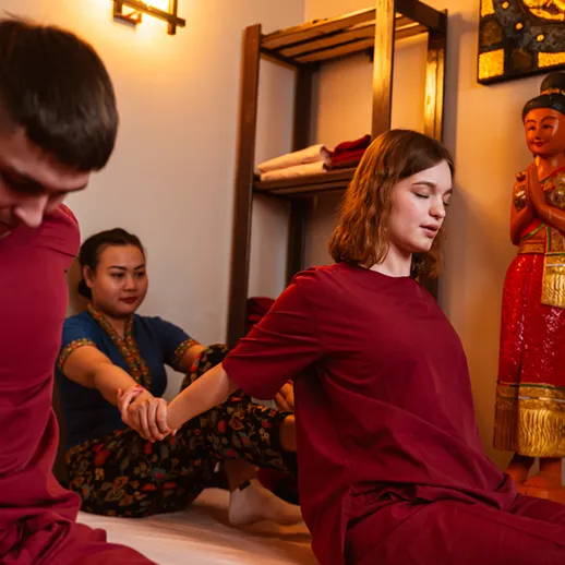 Массажная сессия в спа-салоне, где пара наслаждается расслабляющими процедурами в уютной атмосфере