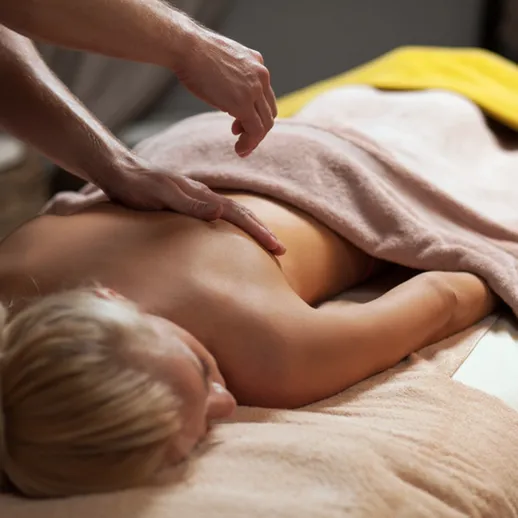 Релаксационный массаж спины в спа-салоне с уютной атмосферой и профессиональным массажистом