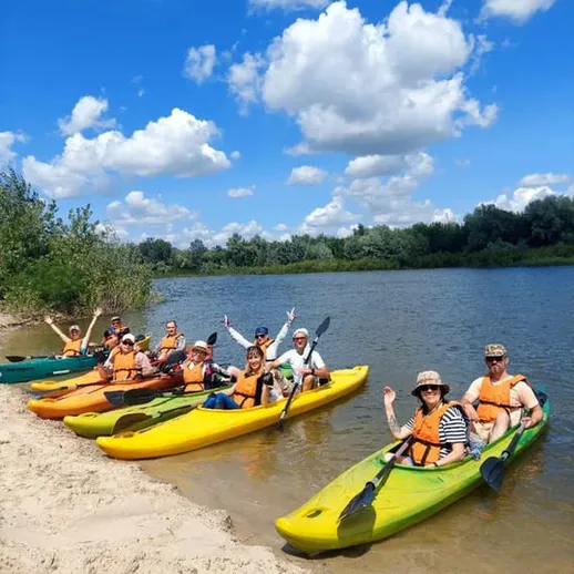 Групповая каякинговая прогулка по реке в ясный солнечный день с друзьями