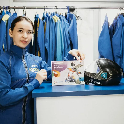 Молодая женщина в синей униформе представляет услуги аквапарка в торговом центре