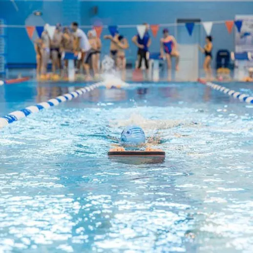 Тренировка пловцов в спортивном бассейне в вечернее время