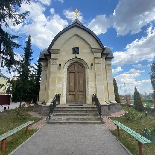 Маленькая церковь в парке на фоне облачного неба, расположенная в городе, летом в ясный день