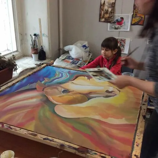 Девочка и женщина рисуют картину с лошадью в художественной студии на светлом фоне