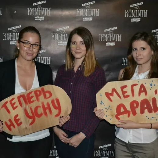 Три девушки на мероприятии держат забавные таблички с лозунгами в Москве