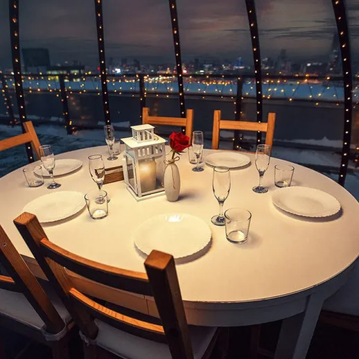 Уютный стол для ужина с видом на город в зимний вечер